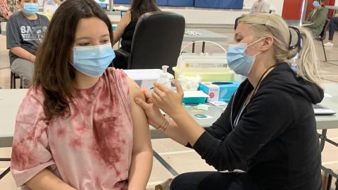 A teenager receives a vaccination