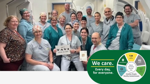 Group of people gathered for a photo in the cardiac cath lab