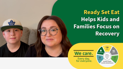 A landscape-orientation photo of a mother and child sitting on a couch. Both are wearing dark-coloured shirts. The mother is wearing glasses, a gold chain, and has long, dark hair. The child is wearing a Toronto Maple Leafs baseball cap.
