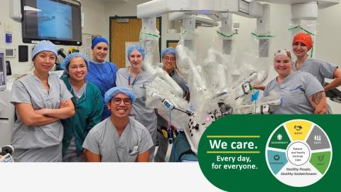 A group photo of the Pasqua surgical team standing in front of the daVinci robot.