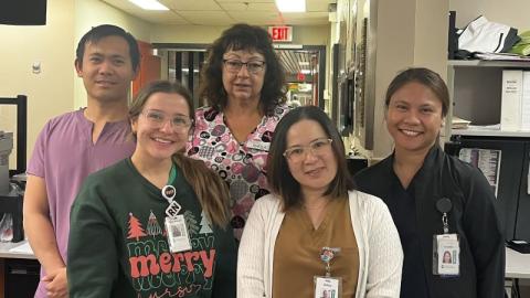 A group of five health-care workers posing together for a photo.