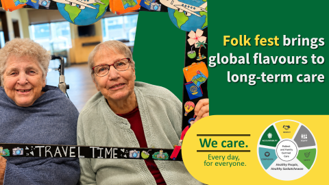 Two smiling long-term care residents pose with a handmade “Travel Time” frame decorated with travel-themed artwork, including airplanes, globes and suitcases, during a folk fest celebration. Text on the image reads, “Folk fest brings global flavours to long-term care,” alongside the Saskatchewan Health Authority’s “We care. Every day, for everyone.” branding and values wheel.