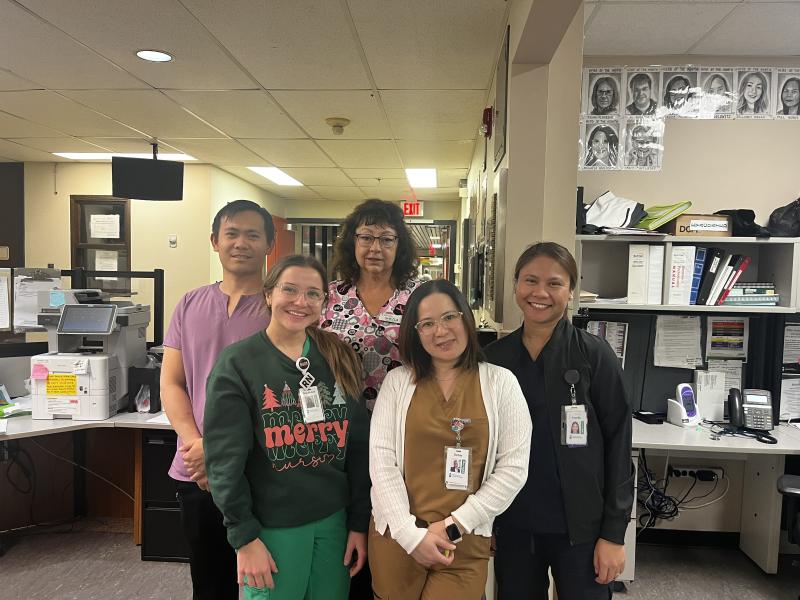 A group of five health-care workers posing together for a photo.