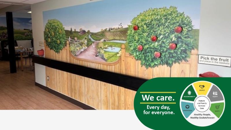 A photo of a wall featuring artwork of an apple orchard with the ability to 'pick the fruit' off the trees.